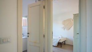 Ein Zimmer mit einem Bett, einem kleinen Tisch, einem Schrank und einem Gegenstand an der Wand.