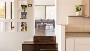 A modern interior with a staircase, a seating area with a sofa and coffee table, and built-in shelving with books and plants. - GuestHost - Wonderful apartment that accommodates up to 4 people, on two levels and equipped with all comforts, including a large terrace overlooking the city and the hills. The accommodation is located in a modern condominium complex with a shared swimm (Perugia)