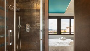 A modern bathroom with a glass shower enclosure, a visible towel rack, and a bed with a view of the cityscape. - GuestHost - Wonderful apartment that accommodates up to 4 people, on two levels and equipped with all comforts, including a large terrace overlooking the city and the hills. The accommodation is located in a modern condominium complex with a shared swimm (Perugia)