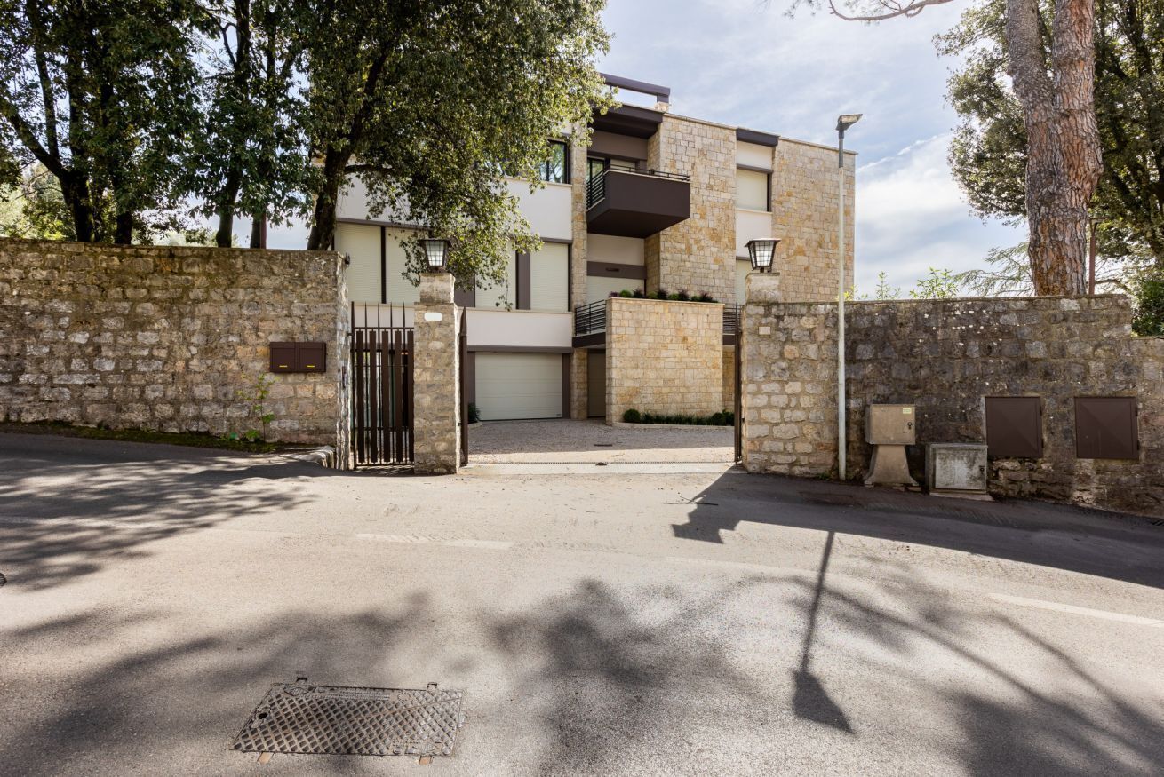 Un bâtiment moderne doté d’une façade en pierre, d’une entrée sécurisée et d’un escalier menant aux étages supérieurs.