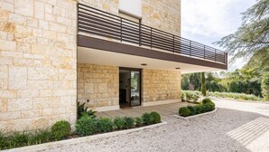 A modern building with stone facade, a balcony with metal railings, and a gravel driveway. - GuestHost - Cozy apartment equipped with all comforts to accommodate up to 6 people, with two bedrooms and two bathrooms. The accommodation is located in a modern condominium complex with a shared swimming pool and enjoys a pleasant view of the shared ga (Perugia)