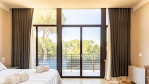 A bedroom with a large window, a bed, and a radiator.