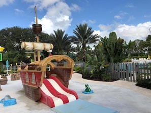 Kids can play and climb on the pirate-themed slide structure with a striped design.