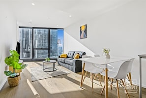 Enjoy the urban view from this stylish living space with a large window, comfortable sofa, and dining area.