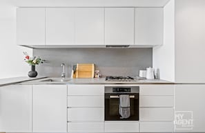 Enjoy cooking in this well-equipped kitchen with an oven, stainless steel sink, and ample countertop space.