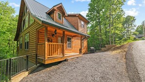 A log cabin with a porch, a covered front porch area, and a gravel driveway. - Centrally Located!~Newly Built Rustic Modern Cabin!~Guest Favorite! (Sevierville)