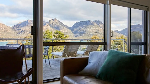 A balcony with a leather sofa and chairs, overlooking a mountainous landscape. - The Arthouse Freycinet (Glamorgan-Spring Bay)