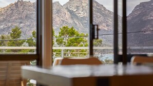 A dining area with a view of mountains and a lake. - The Arthouse Freycinet (Glamorgan-Spring Bay)