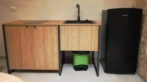 A compact kitchenette with a wooden cabinet, a black sink, and a black refrigerator. - Locus Pendinelli Trani 53-the Philosophy of a B&b, the Details of a Hotel!!! (Trani)