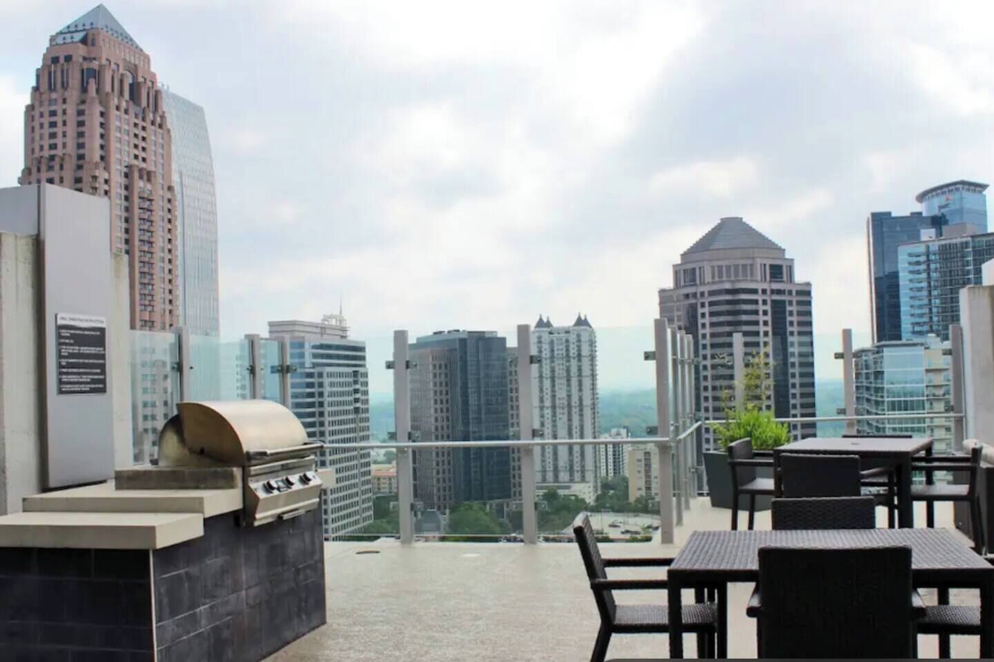 Une terrasse sur le toit équipée d’un barbecue, d’un espace salon et offrant une vue panoramique sur la ville.