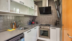 A kitchen with a dishwasher, stove, microwave, and cabinets. - Holiday Home 'Sunny House' with Sea View, Wi-Fi and Air Conditioning (Sant Pere de Ribes)