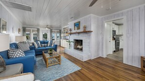 Un salon spacieux avec une cheminée, un canapé bleu et une table basse en bois.