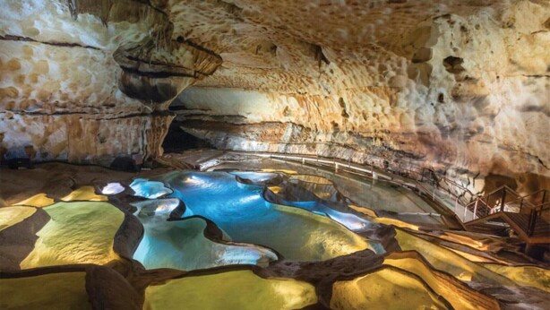 A cave interior with stalactites, a pool of water, and a wooden walkway. - Apartment 'Appartement Des Cedres' with Shared Pool, Wi-Fi and Air Conditioning (Uzès)