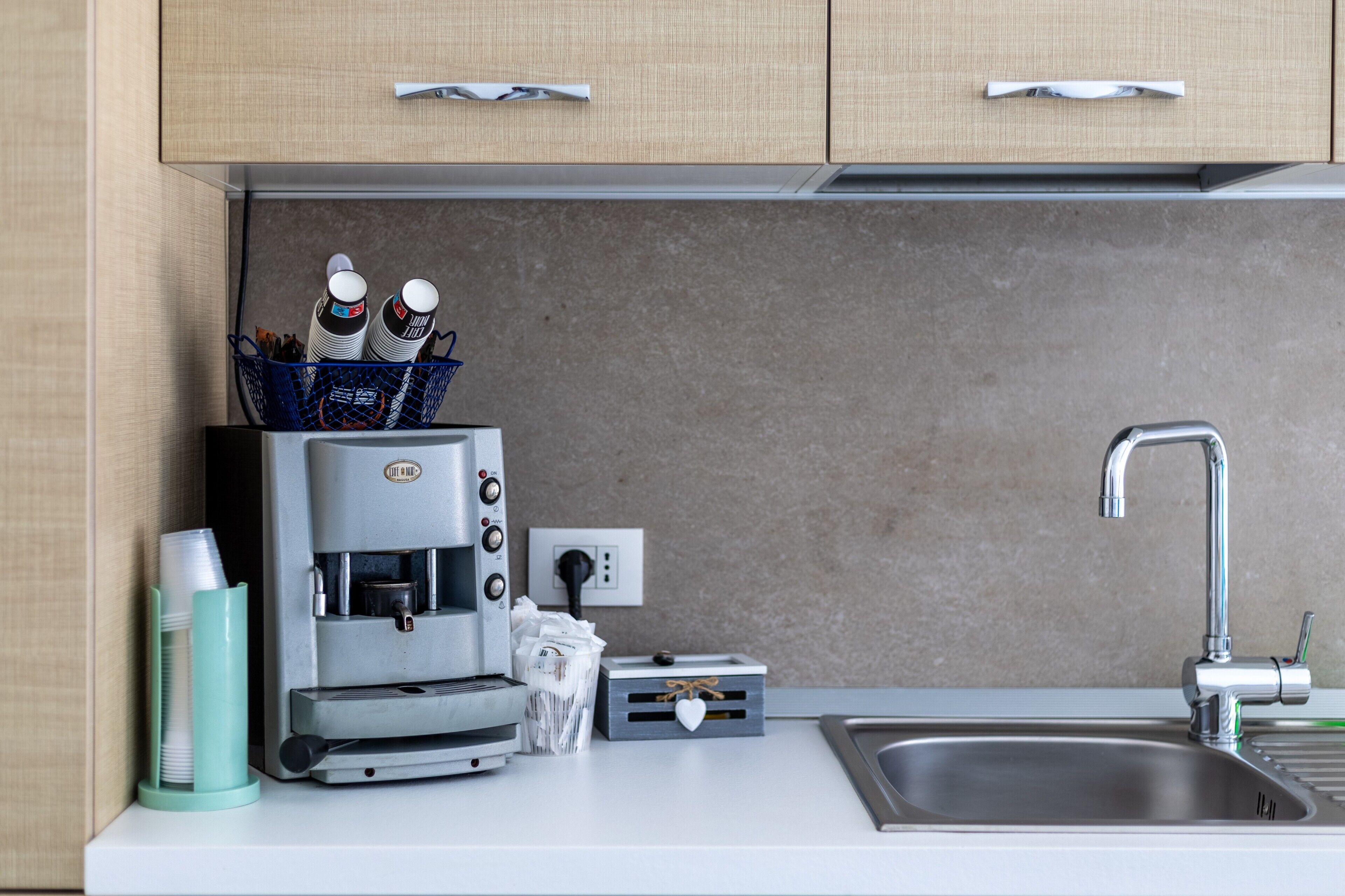 A kitchen with a coffee machine, a sink, and a countertop.