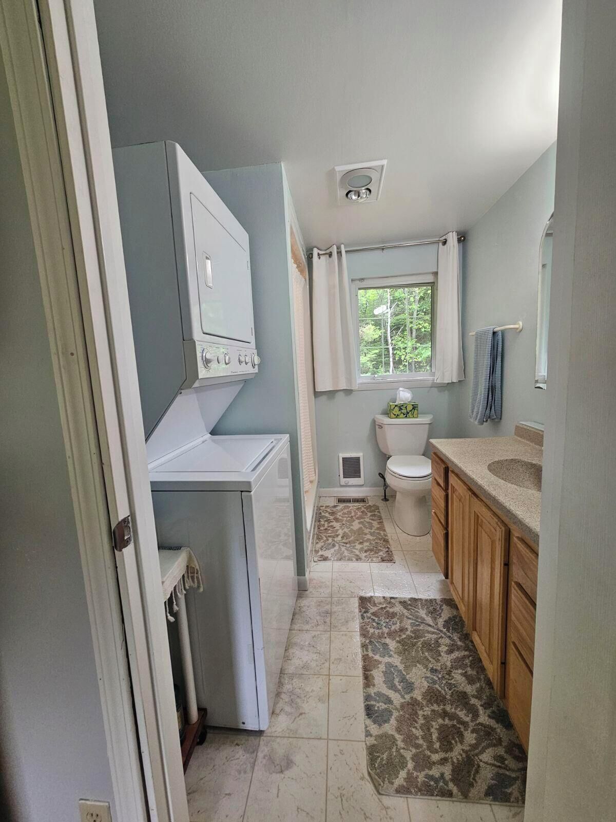 A bathroom with a toilet, sink, and a white washing machine.