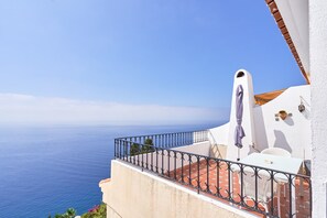 A balcony with a view of the sea, a white building, and a red-tiled floor. - Apartment 'Atalaya' with Sea View, Wi-Fi and Air Conditioning (Almuñécar)
