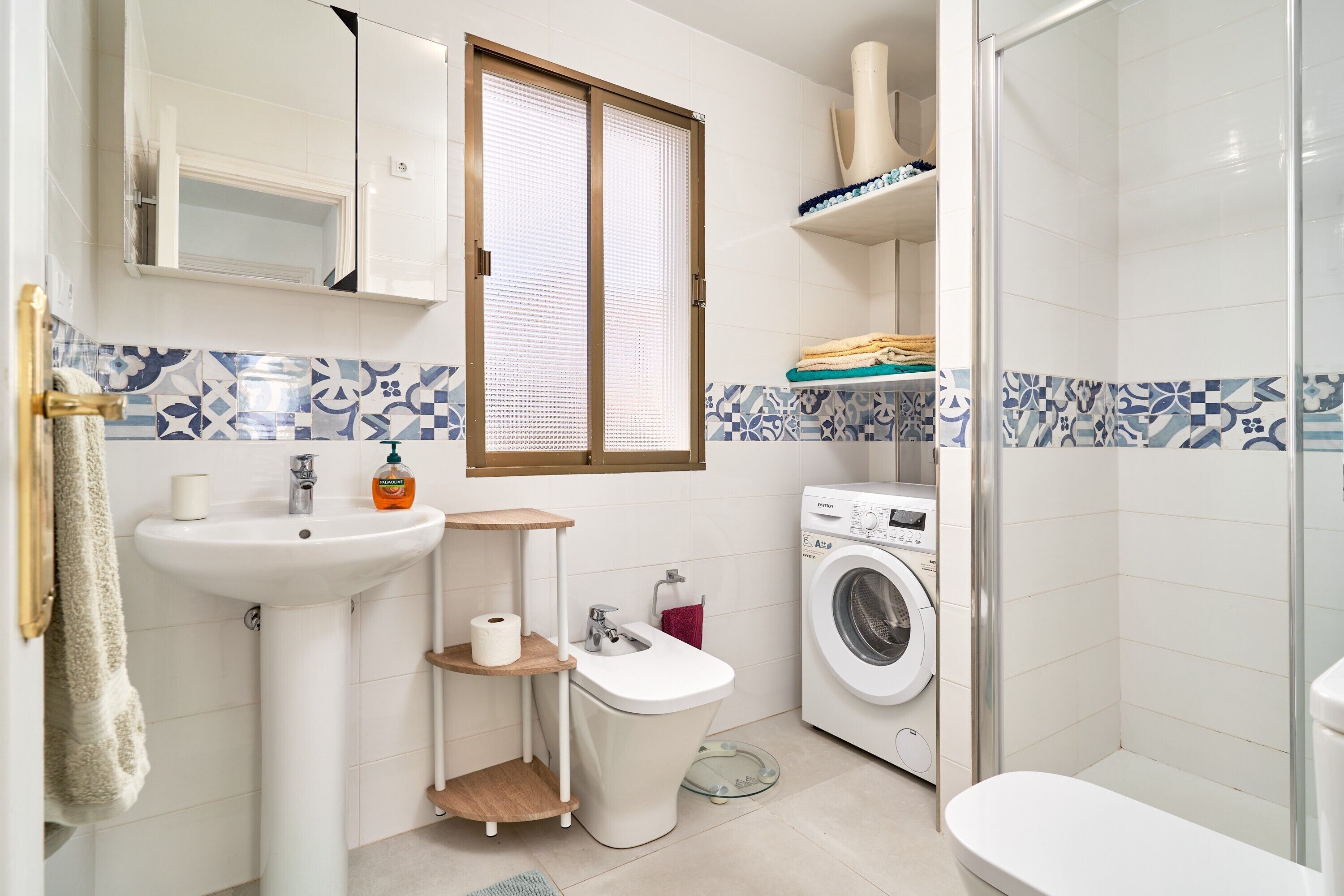 Ein kleines Badezimmer mit Waschbecken, Toilette, Bidet und Waschmaschine.