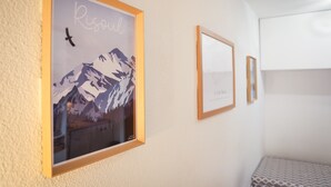 A room with a framed picture of a mountain, a bed, and a small table. - Apartment 'Appartemment 6 Couchages Risoul' with Mountain View and Balcony (Risoul)