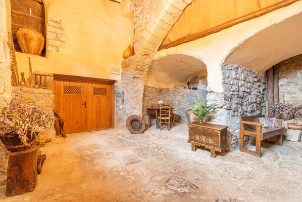 Un intérieur rustique avec des murs en pierre, des meubles en bois et un plafond voûté.