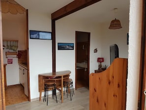 A compact living space with a kitchen, dining area, and a small bathroom.
