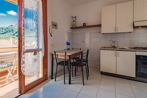 Een keuken met een eettafel, stoelen, een fornuis en een vaatwasser.