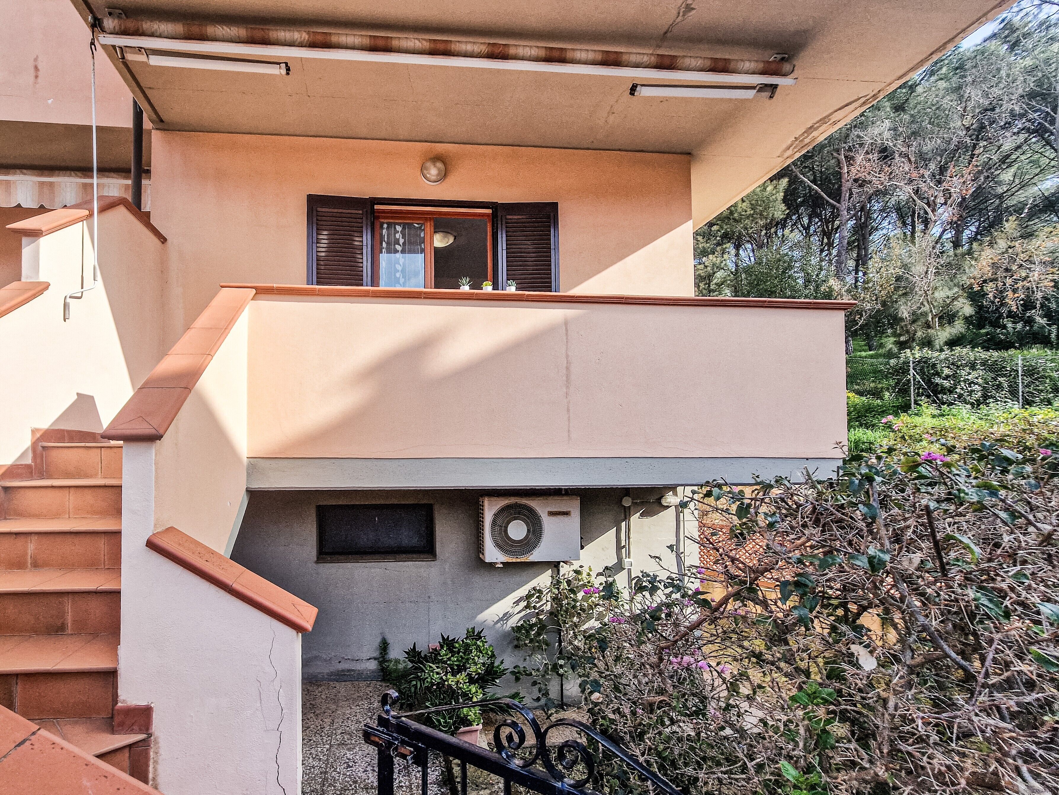 Un bâtiment à deux étages doté d’un balcon, d’un escalier et d’un appareil de climatisation.