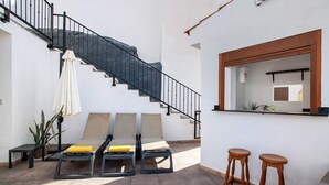 A sunlit patio with lounge chairs, a wooden staircase, and a bar area. - Vacation Home 'Casa Celestina' with Mountain View, Wi-Fi and Air Conditioning (Temisas)