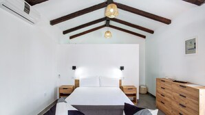 A bedroom with a bed, bedside tables, a dresser, a hanging light fixture, and a ceiling fan. - Vacation Home 'Casa Celestina' with Mountain View, Wi-Fi and Air Conditioning (Temisas)