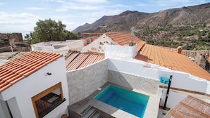 A rooftop pool with a view of the mountains, a stone wall, and a wooden pergola. - Vacation Home 'Casa Celestina' with Mountain View, Wi-Fi and Air Conditioning (Temisas)