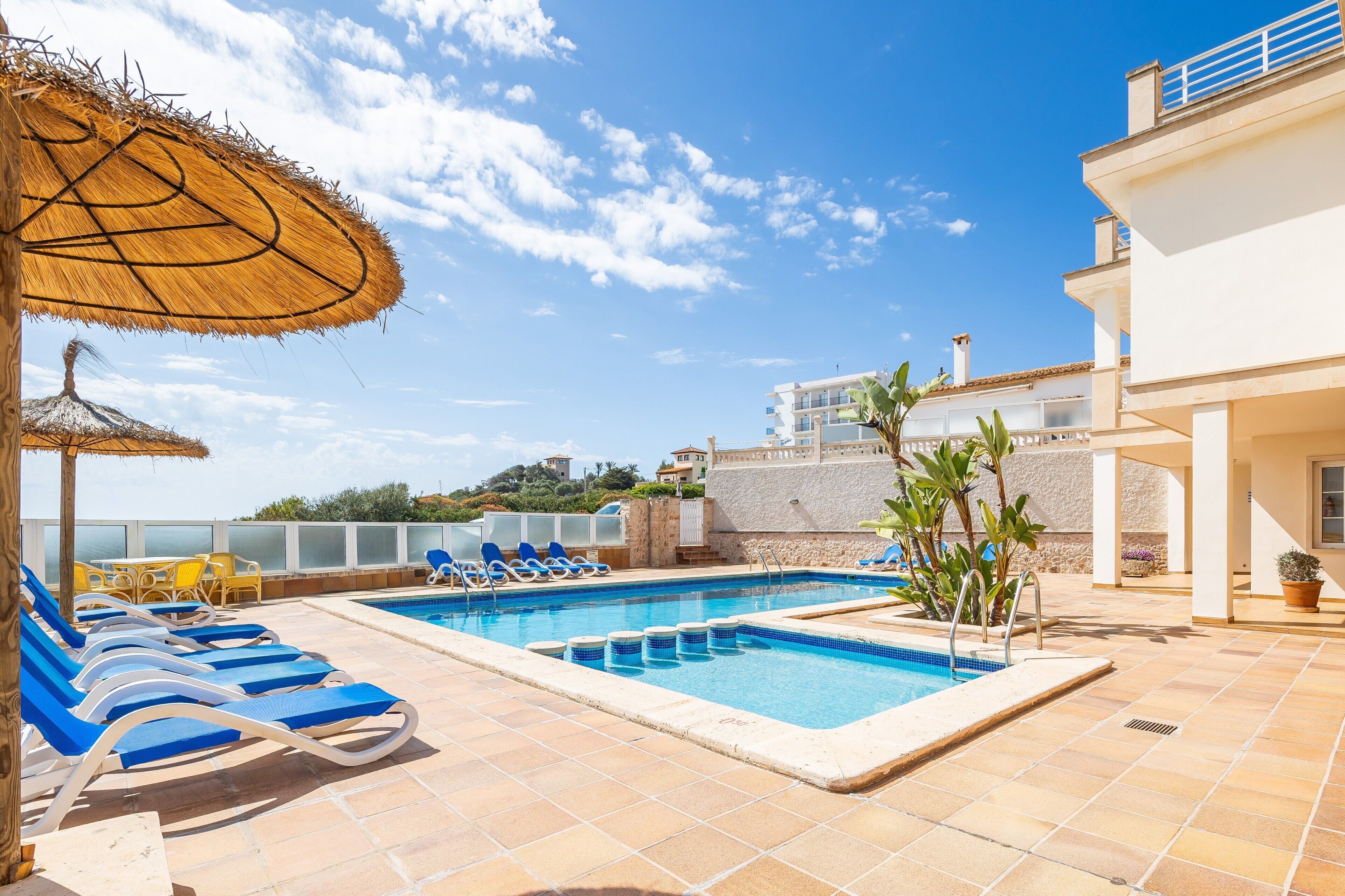Area piscina con lettini, una piscina e vista sul mare.