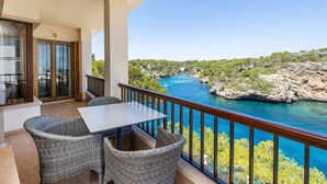 A balcony with wicker furniture and a view of a river and rocky landscape. - Apartment 'Vista Al Mar Y Vista Puerto' with Sea View, Wi-Fi and Air Conditioning (Cala Figuera)