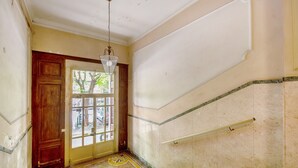 A staircase with a handrail, a wooden door, and a patterned floor. - Apartment 'Ohana Bnb' with Wi-Fi (Genova)