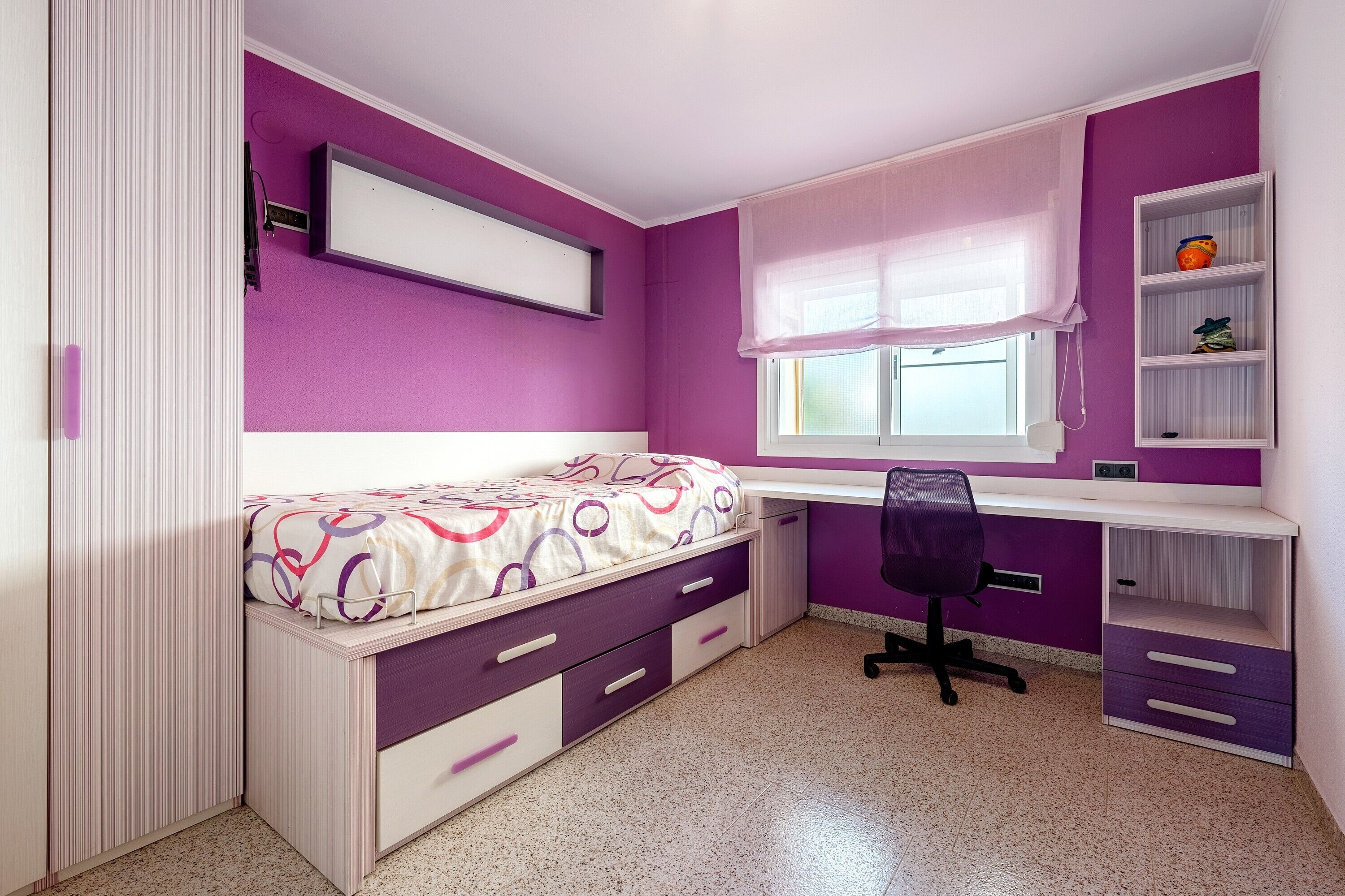 Une chambre à coucher comprenant un lit, un bureau, une chaise et une étagère.