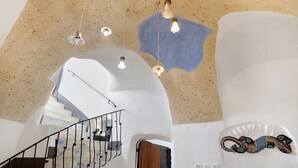 Un interior moderno con un diseño de techo único, una escalera y un elemento decorativo en la pared.