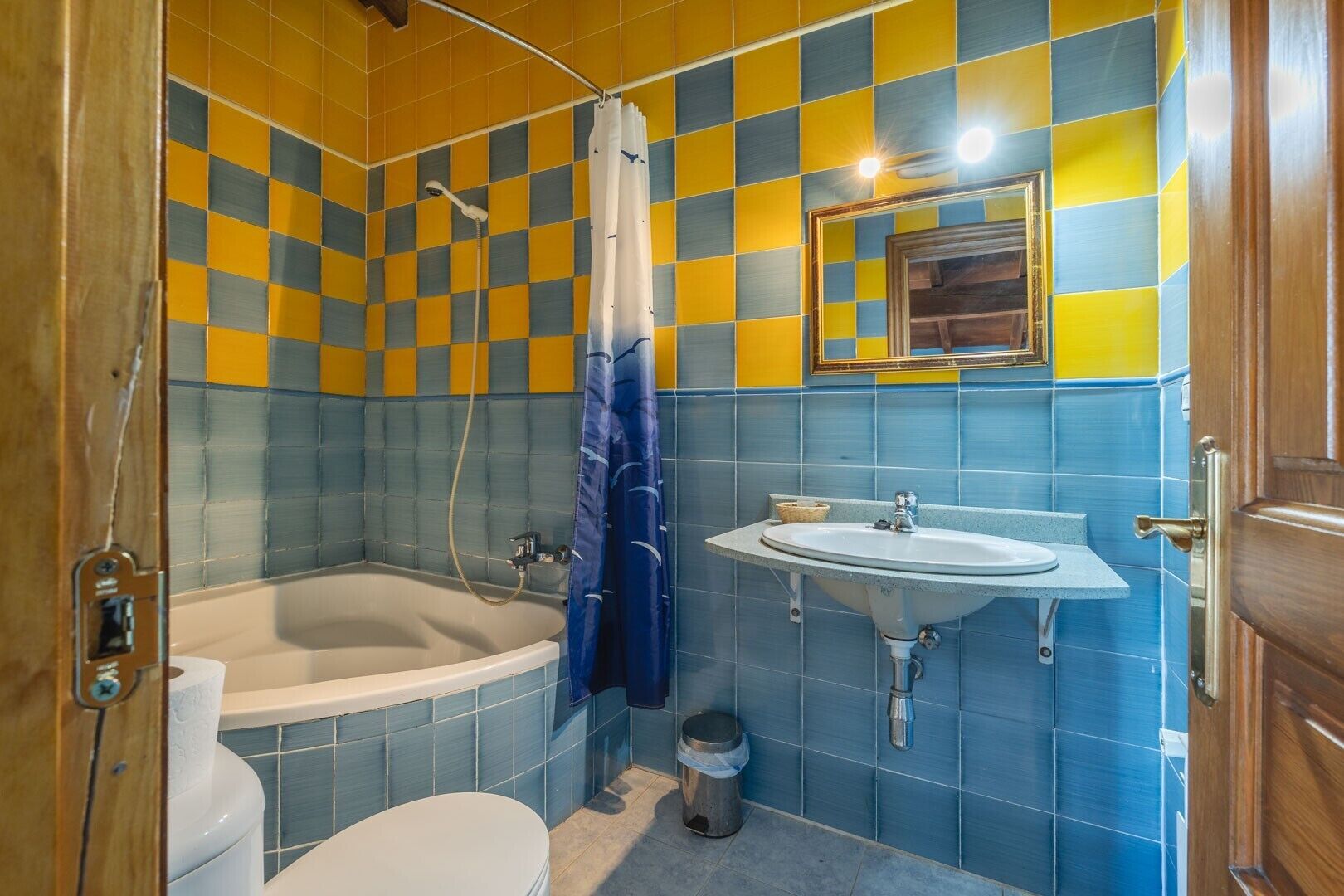 Ein Badezimmer mit Badewanne, Toilette, Waschbecken und Spiegel.