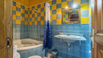 Ein Badezimmer mit Badewanne, Toilette, Waschbecken und Spiegel.