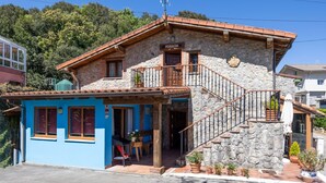 A stone building with a blue facade, a staircase, and a sign reading 'POSADA'.