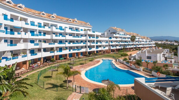 A resort with multiple-story buildings, a central swimming pool, and outdoor seating areas. - Apartment 'Duquesa Suites Golf and Gardens' with Shared Pool, Wi-Fi and Air Conditioning (Manilva)