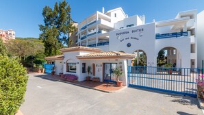 A building with a sign reading 'DUQUESESA SUITES Golf and Gardens.' - Apartment 'Duquesa Suites Golf and Gardens' with Shared Pool, Wi-Fi and Air Conditioning (Manilva)