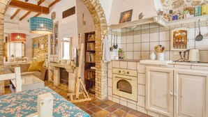 A rustic kitchen with exposed brick walls, a wooden ceiling, and a tiled backsplash. - Designer Country House Near the Sea (La Nucia)