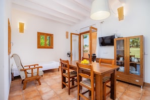 A dining area with wooden furniture, a television, and a cabinet with glass doors.
