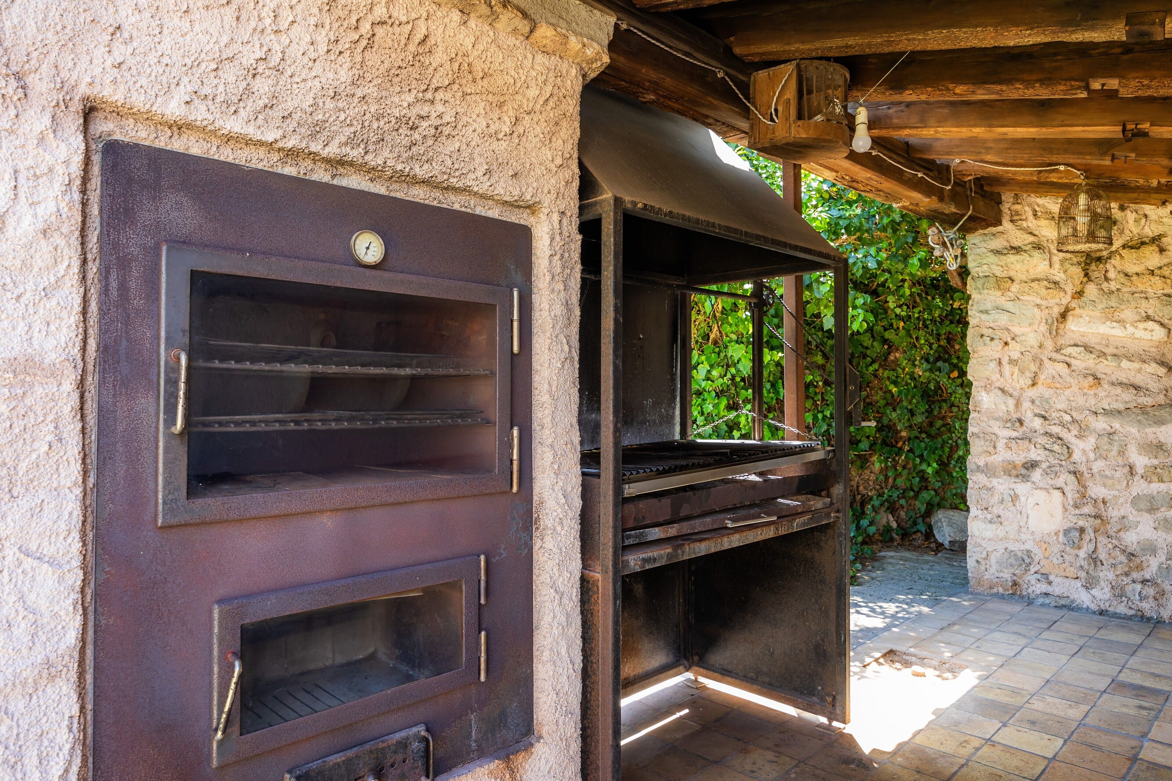Un mur de pierre surmonté d’une grille métallique et d’une structure en bois.