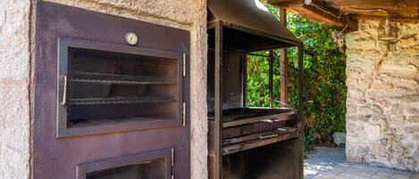 Un mur de pierre surmonté d’une grille métallique et d’une structure en bois.