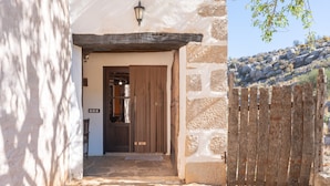 Un edificio de piedra con puerta y cerca de madera.