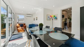 Un comedor moderno con una mesa de vidrio, sillas negras y un sofá azul.