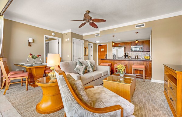 A living room with a sofa, armchairs, a coffee table, and a dining table set for two.