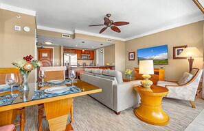 Une chambre d’hôtel comprenant un coin repas, une kitchenette et un espace salon avec un canapé et des fauteuils.
