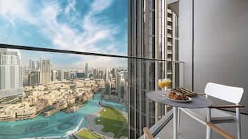 Ein Balkon mit Frühstückstisch, mit Blick auf eine Stadtlandschaft und ein Gewässer.