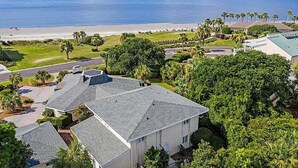 A residential area with houses, a beach, and palm trees. - Fabulous Location! Sleeps 12! Walk to Club/Beach! Amenity access included (Seabrook Island)