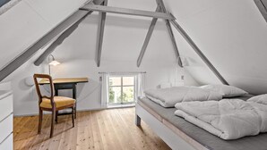 Une chambre avec un lit en mezzanine, une chaise en bois, un bureau et une fenêtre.